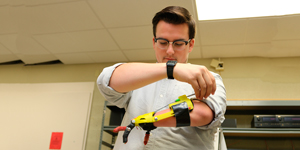 Student adjusting mechanical arm