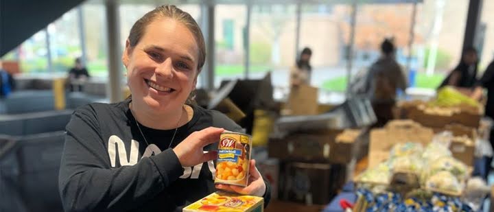 Woman holds food items at basic needs fair