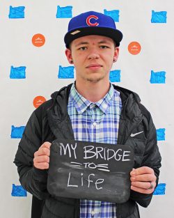 Student holding a sign that says my bridge to life