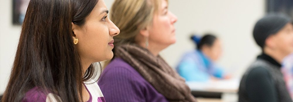  Three female clients look ahead while learning about individual professional career skills in the classroom
