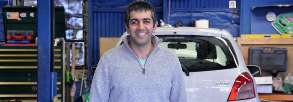 Farhad Ghafarzade owner of Green Drop Garage and graduate of Advanced Small Business Management stands in first Green Drop Garage location.