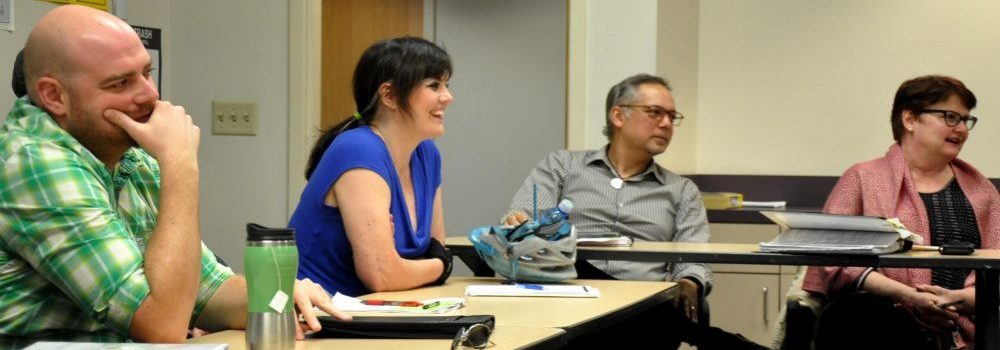 Man and woman sit at table in PCC CLIMB classroom