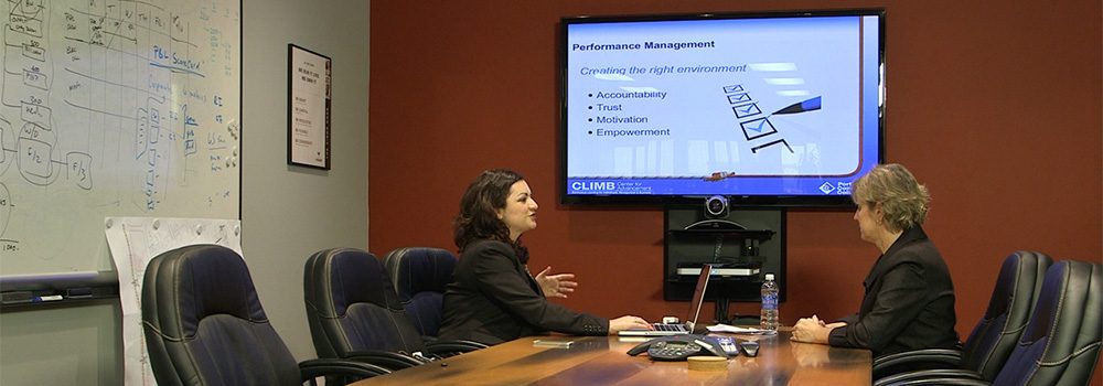 Client sits down in board room with instructor to discuss training PCC can provide for her organization.