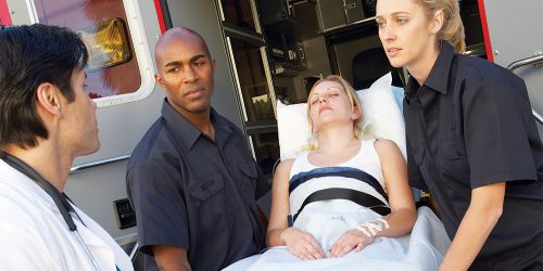 Emergency personnel put patient in ambulance