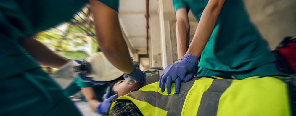 Paramedic team CPR and use ambu bag help unconscious worker accident in construction site.