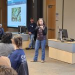 Elizabeth Brewster talking to an audience in a black blazer in a classroom