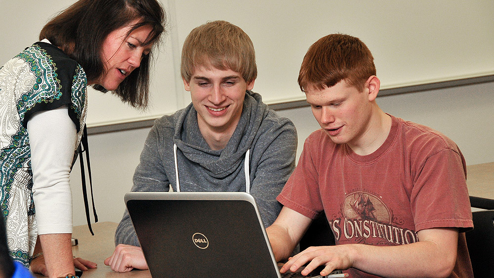 Students working with an instructor at a computer