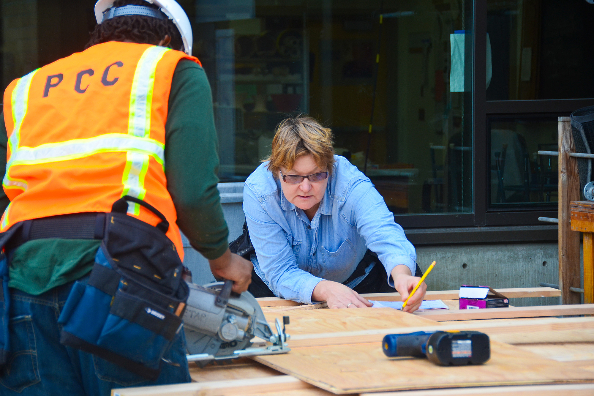 Apprenticeship instructor measuring for a student to make a cut