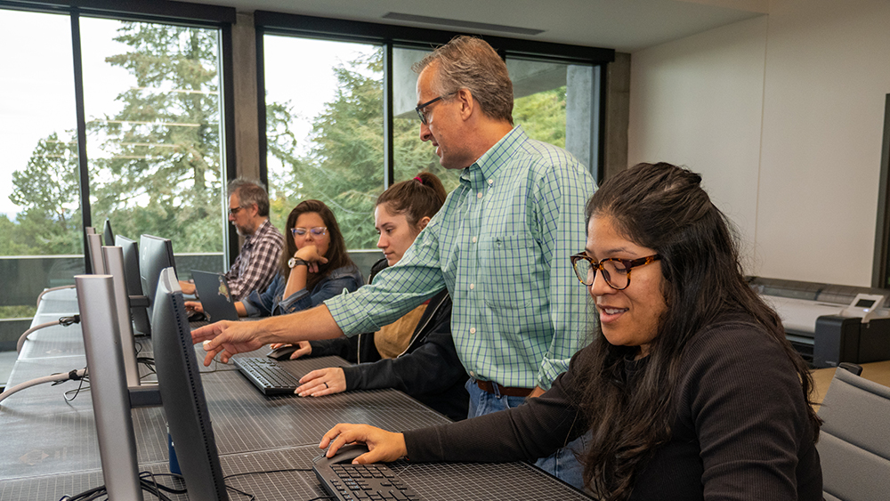 Instructor pointing at student's computer screen