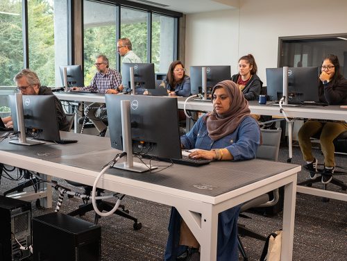 Students sitting in front of computer screens in class