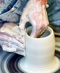 Student throwing on a pottery wheel