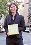 Jacqueline Ehlis holding an artwork on a street in downtown Portland