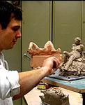 Student working on a clay sculpture of a woman