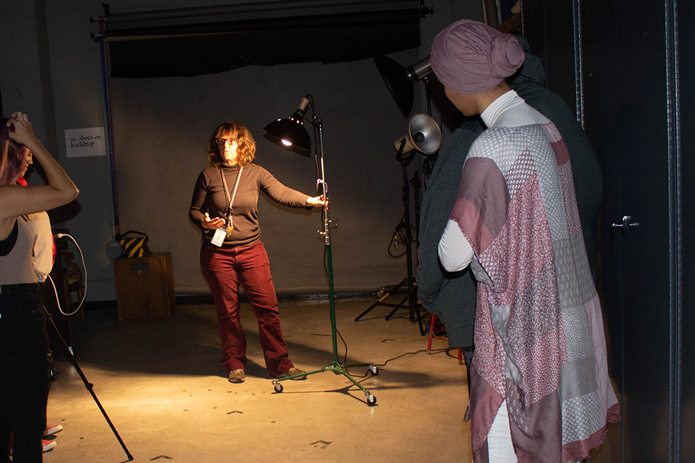 Instructor working with students in the studio on lighting