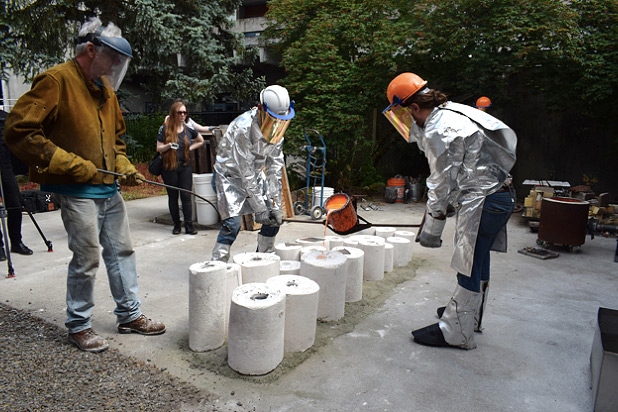 Students outside casting bronze and wearing protective gear