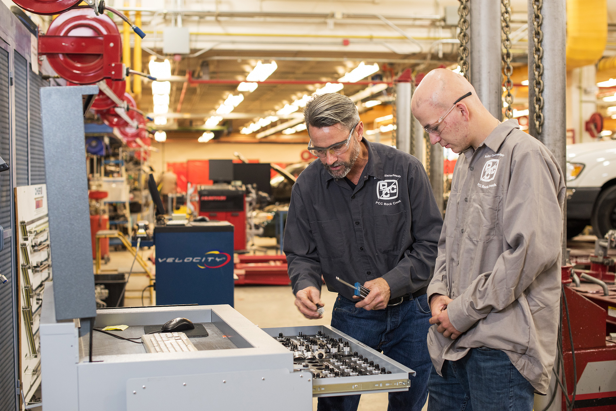 Auto Collision instructor showing a student a drawer of tools in the auto body shop
