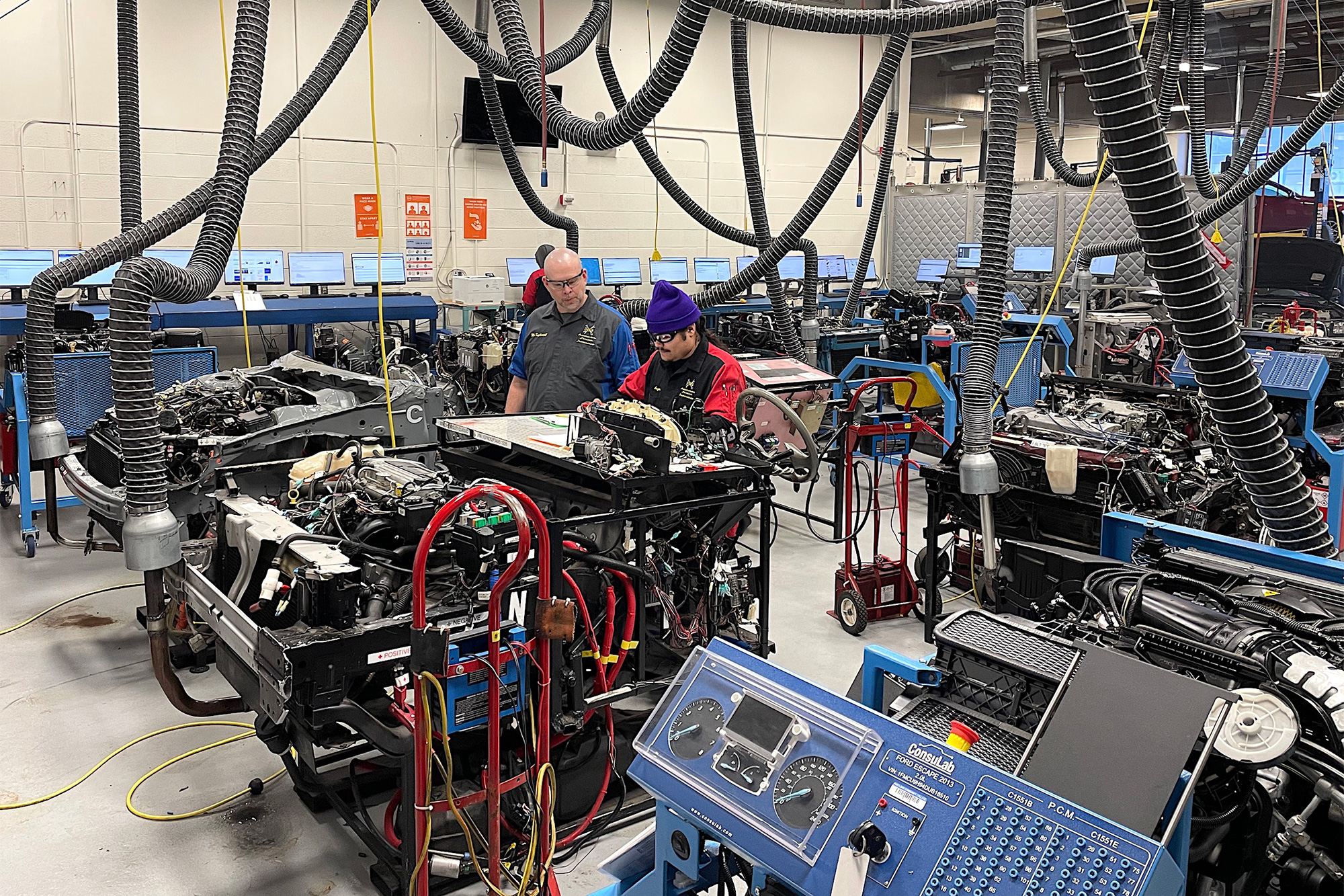 Wide shot of a Auto Service student and instructor in the auto shop