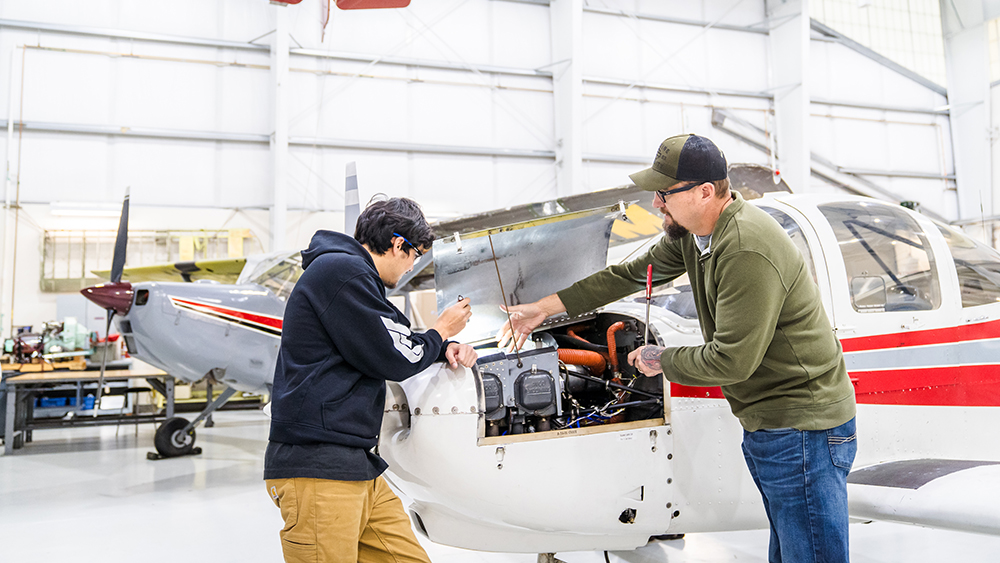 Student and teacher working on an airplane together
