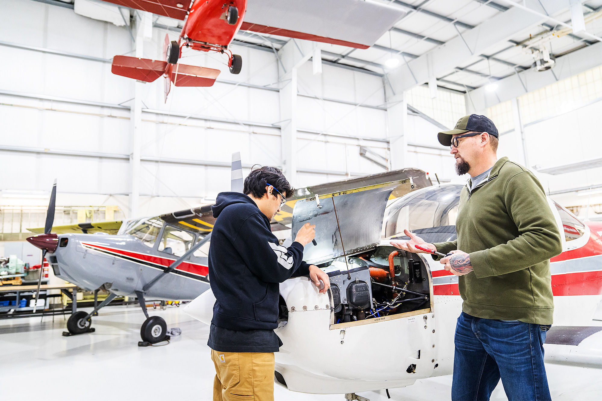 Aviation Maintenance student and instructor working on an airplane engine together
