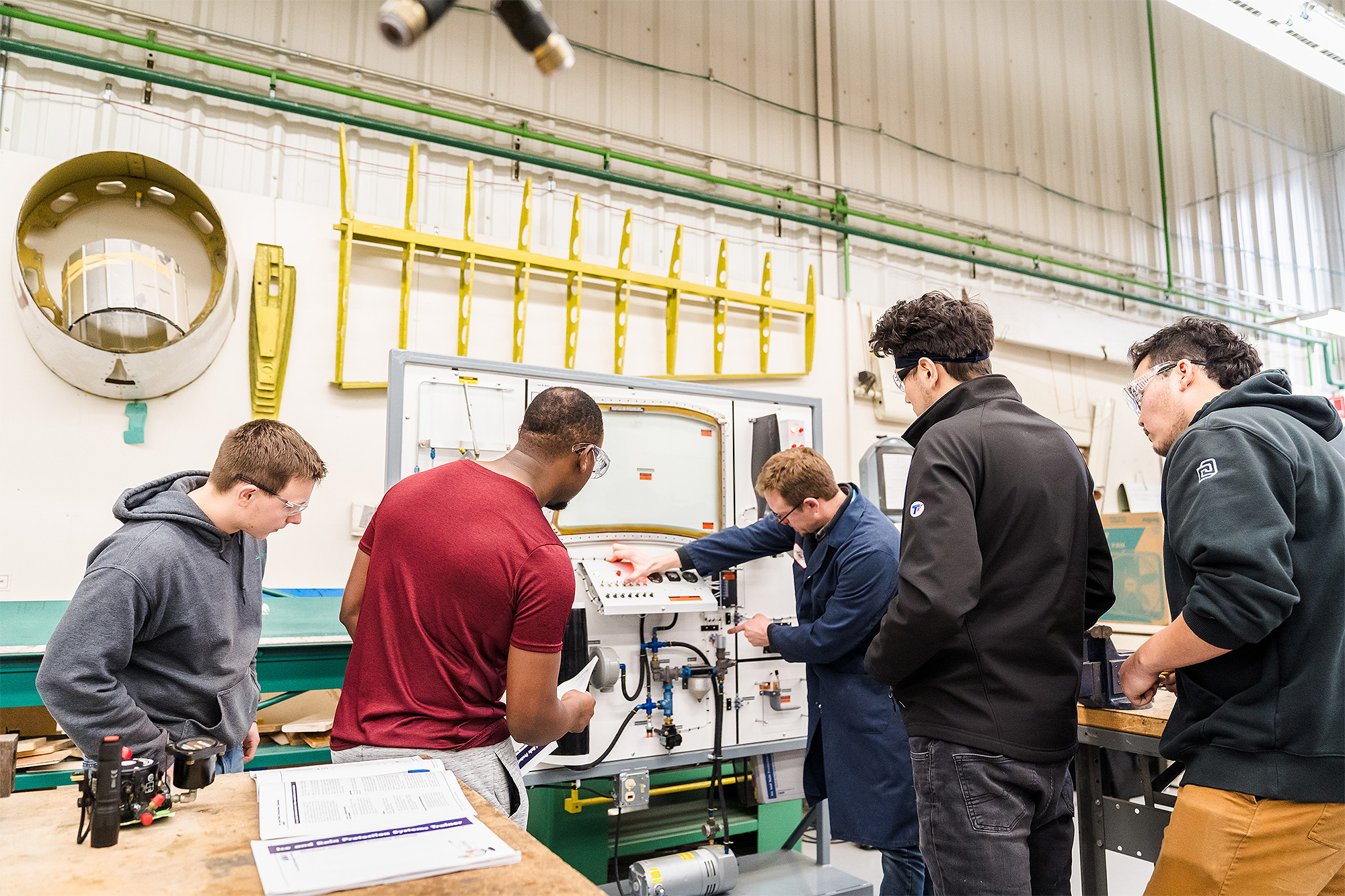 Aviation Maintenance instructor demonstrating using a practice control panel for the students