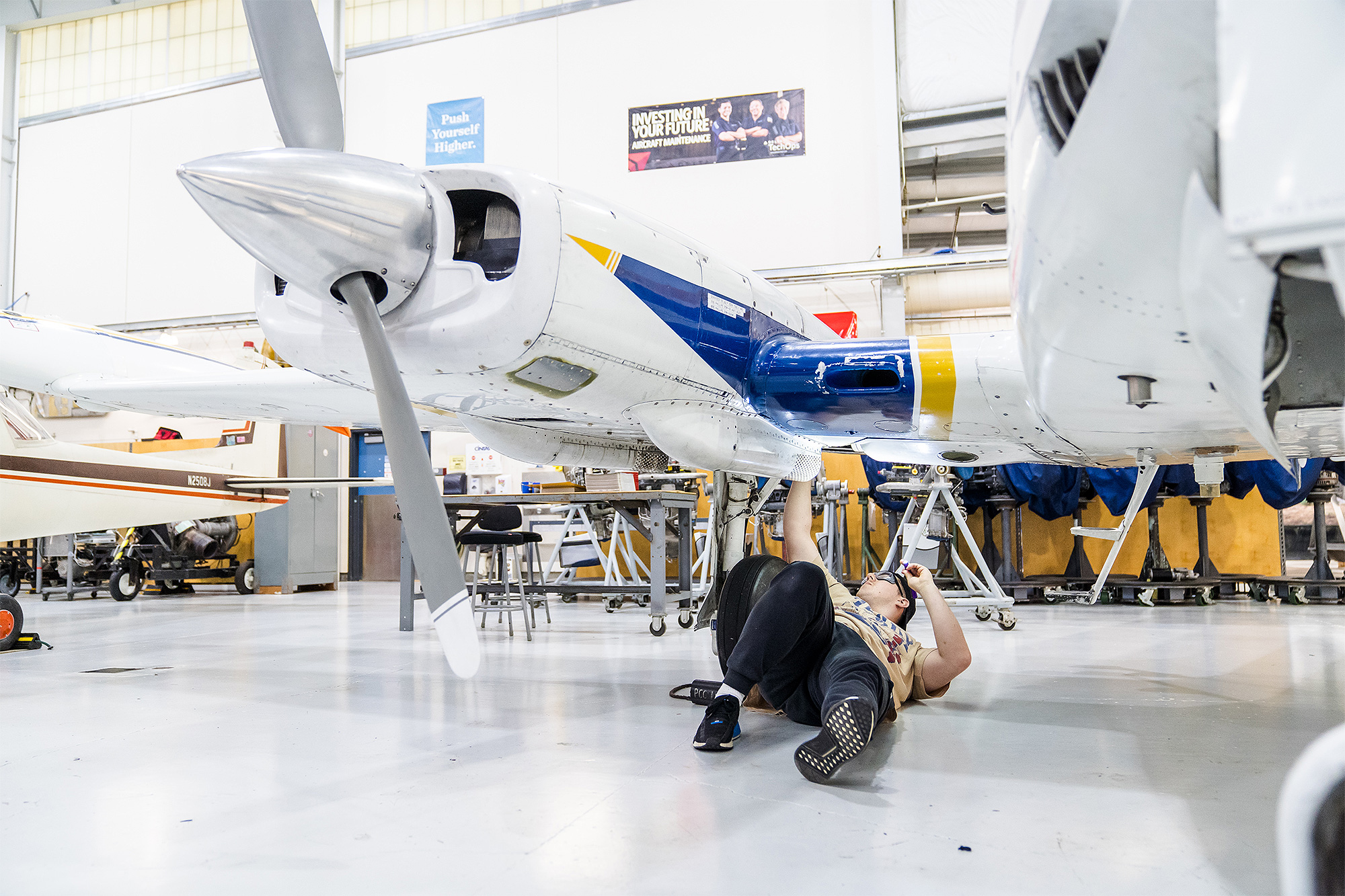 Aviation Maintenance student working on an airplane from below