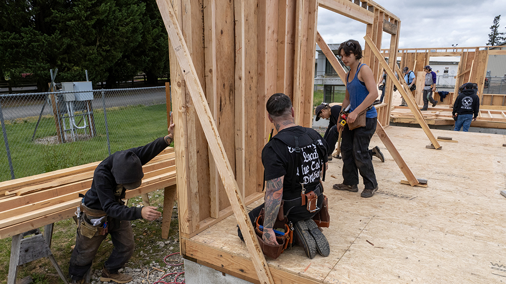 Group of students framing a wall 