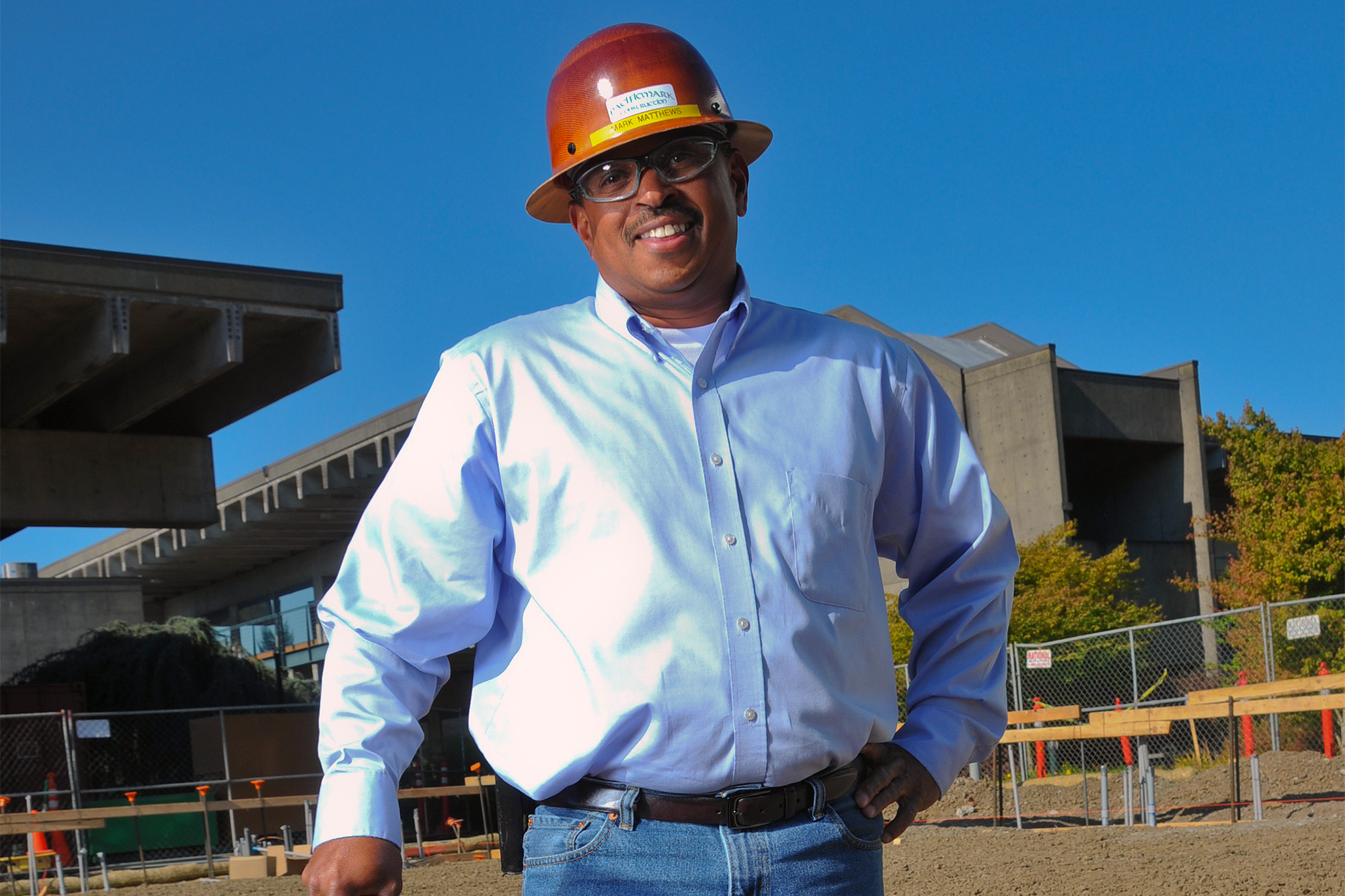 Building Inspection student wearing a hard hat in front of a building exterior