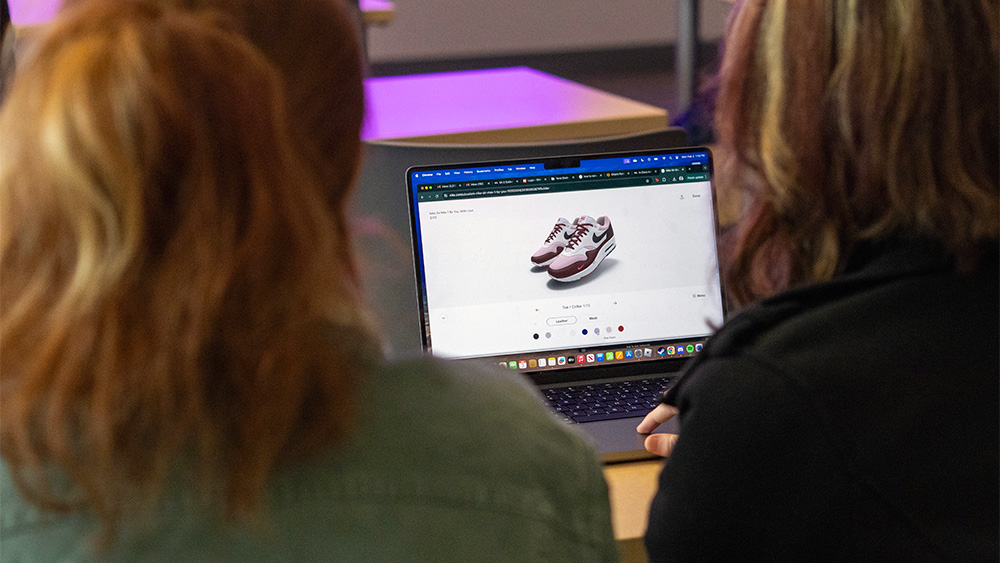 Entrepreneurship students looking at an e-commerce website on a laptop
