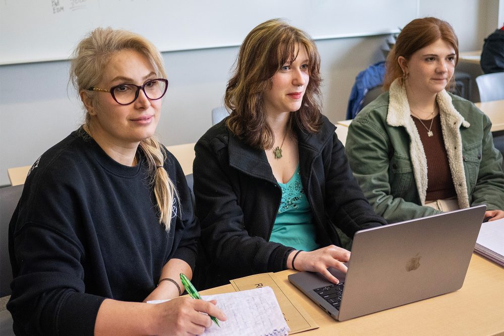 Students watching the instructor and taking notes in class