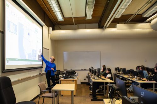Instructor presenting data in front of a business class