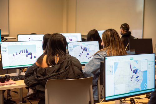 Students looking at data on computers in class