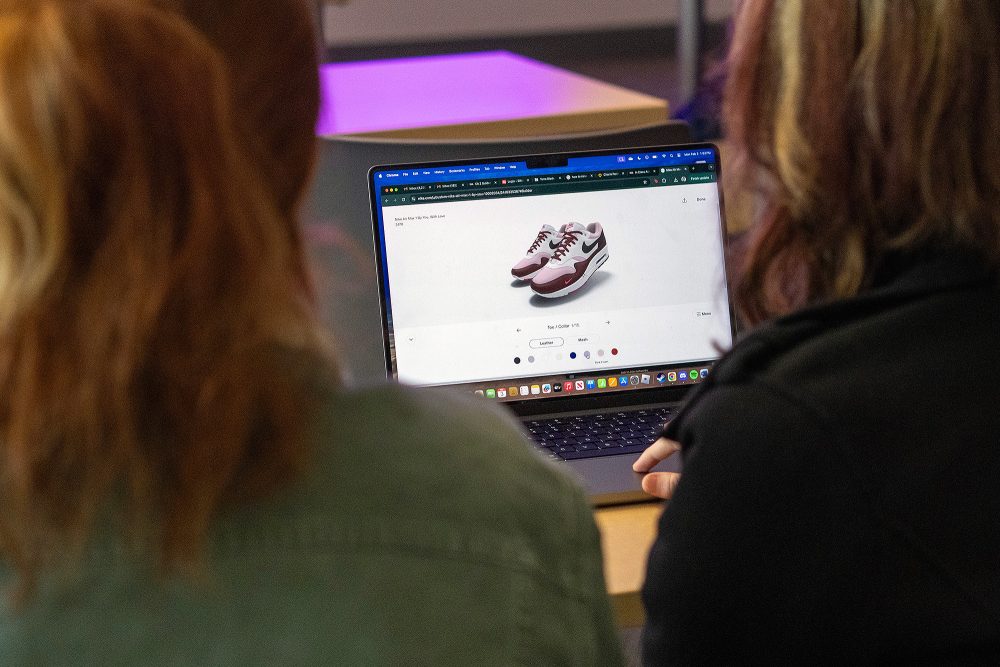 Students looking at an e-commerce site on a laptop together