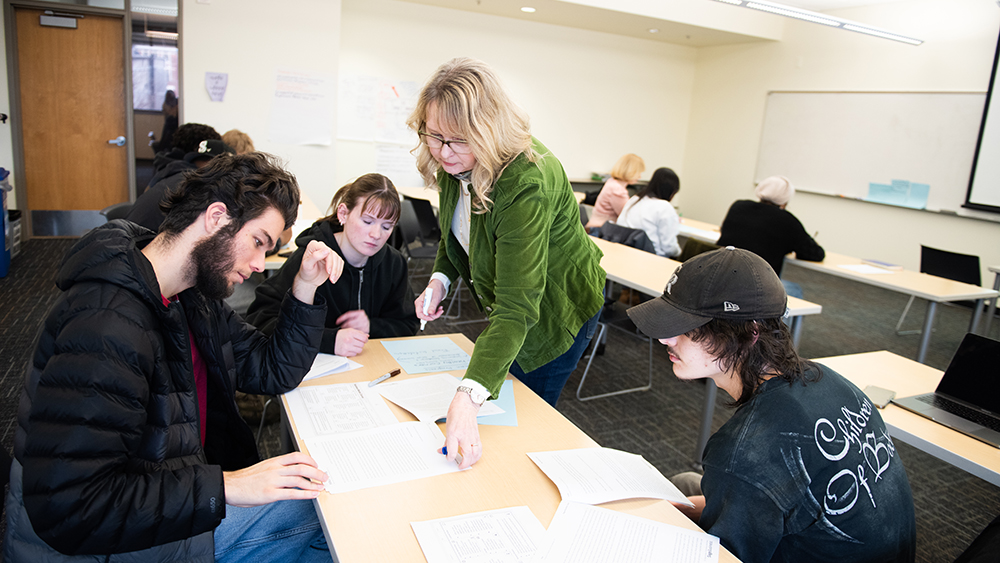 Business administration teacher helping students in class