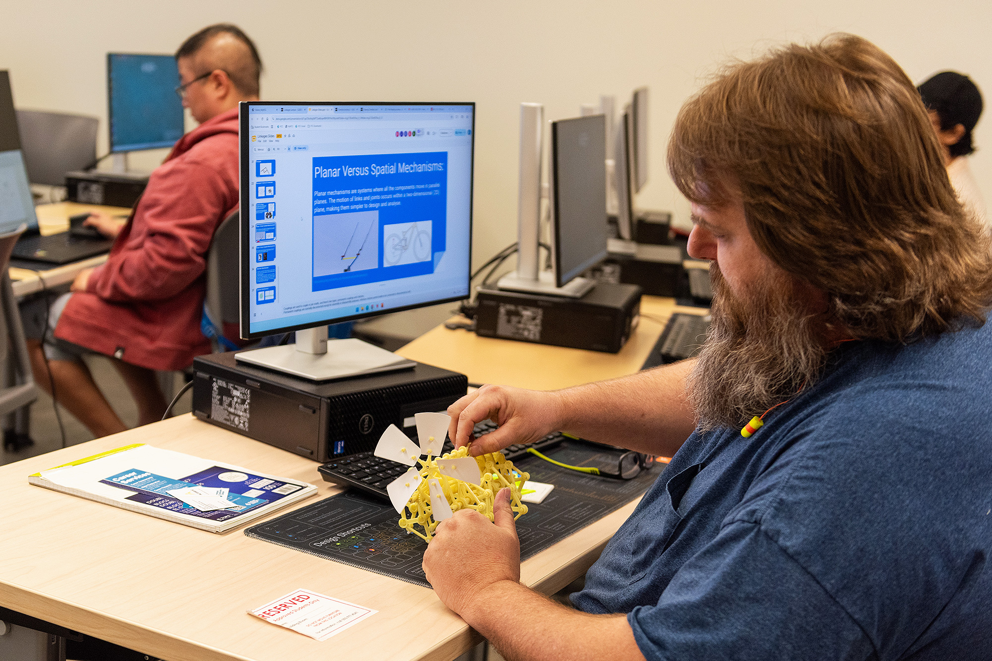 CADD student in class looking at a kinematics machine