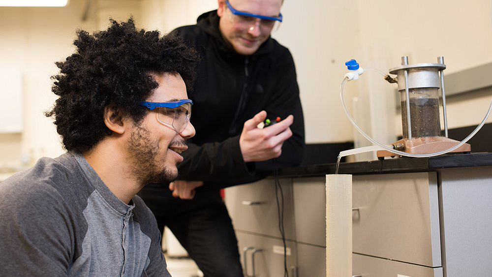 Two students performing an experiment together