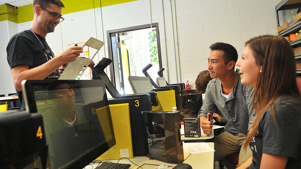 Students sitting at computers and talking together