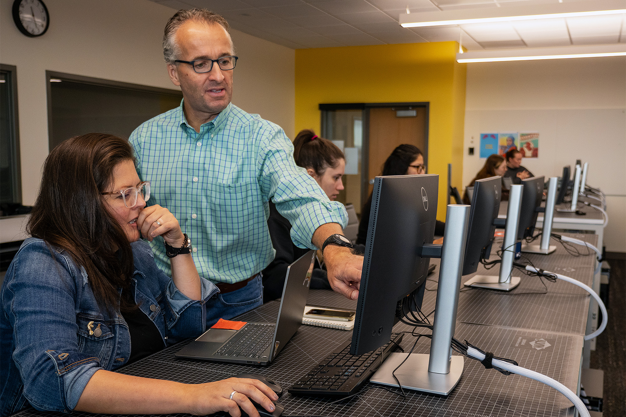 Computer Information Systems instructor helping a student in class