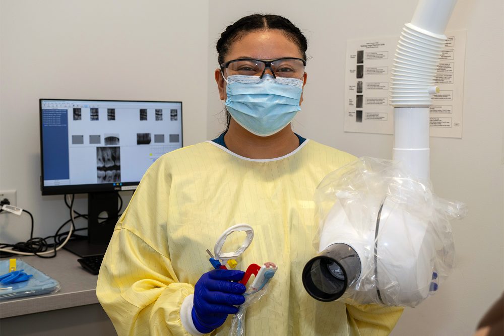 Dental Assisting student holding an X-ray machine and holders
