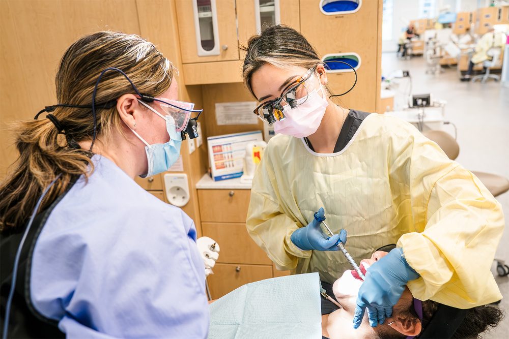 Student giving a shot to a mock patient