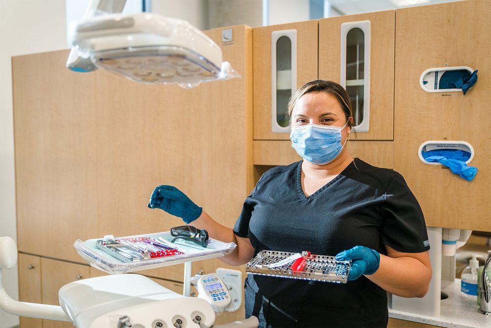 Student holding trays of tools