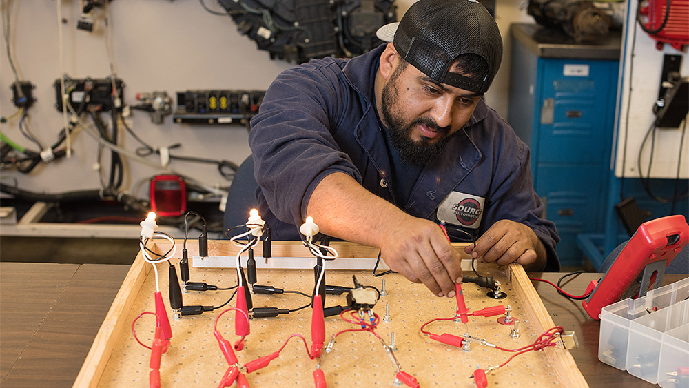 Student working with electronic controls in the shop