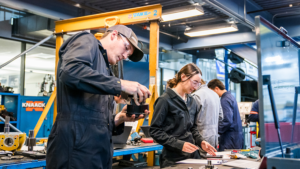 Students working on diesel trucks together in the shop