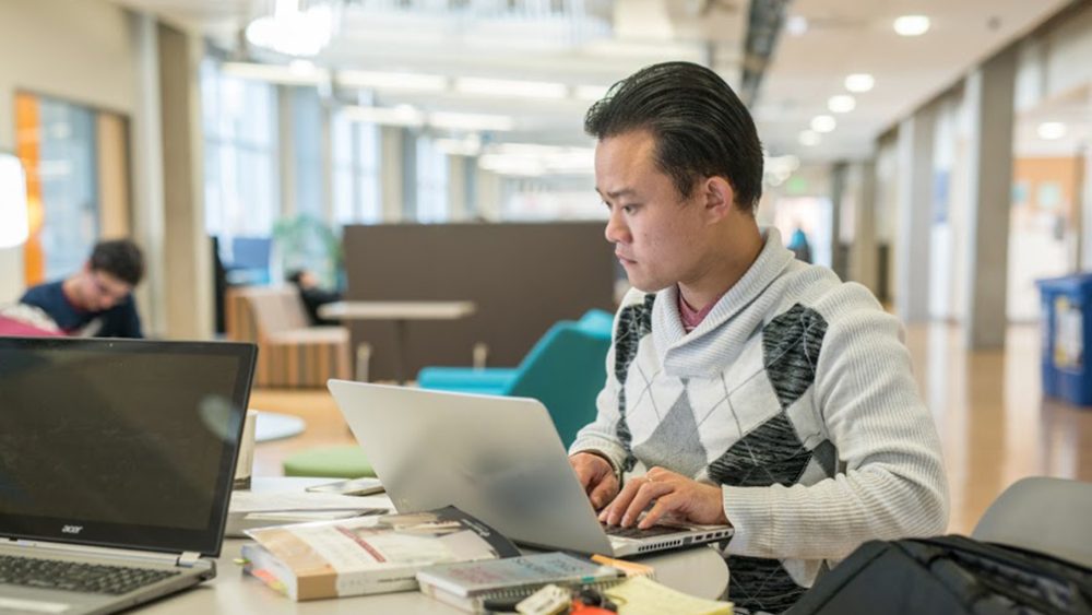 Student working on laptop in study area