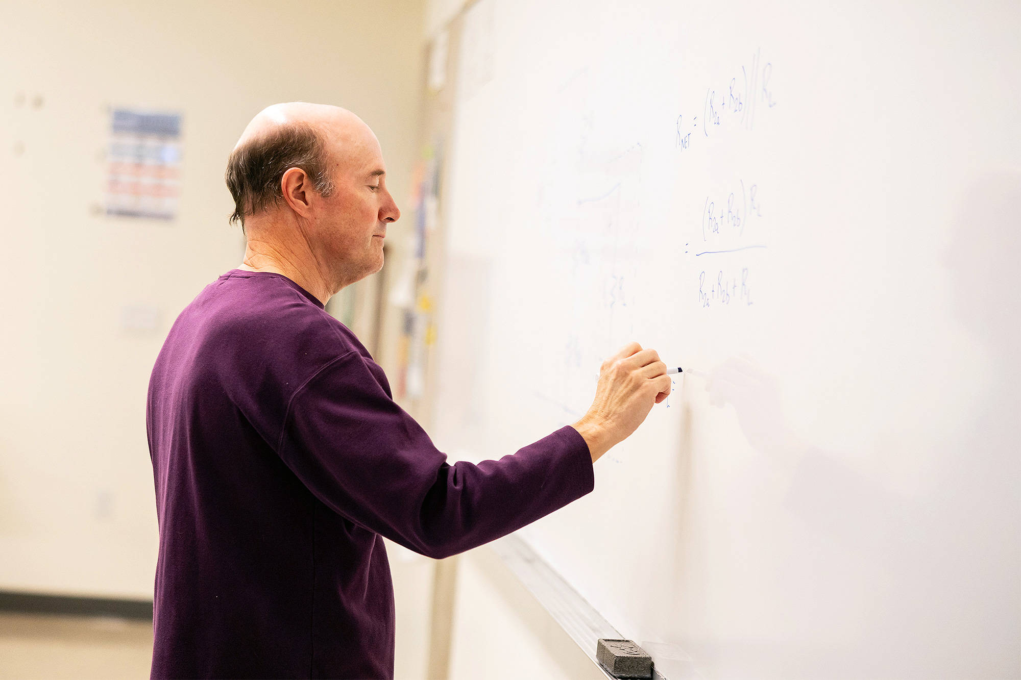 Math teacher writing equations on the whiteboard