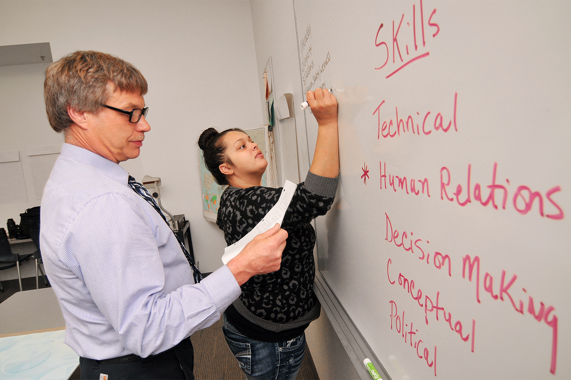 Education students writing skills required for the job on the whiteboard