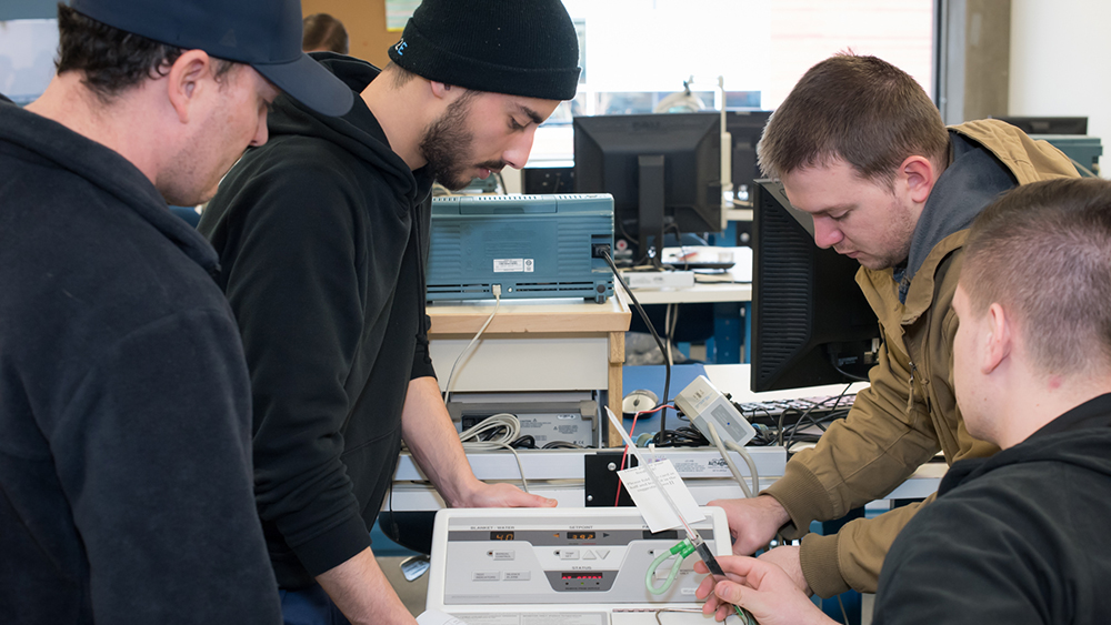 Four students collaborating on biomedical equipment