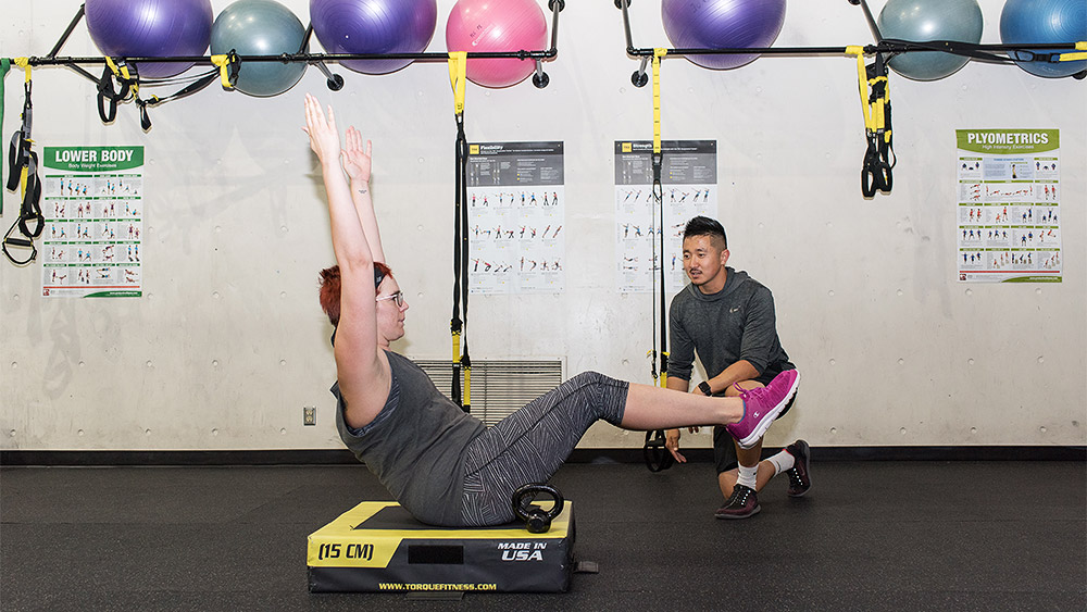 Student working out with an instructor in the gym