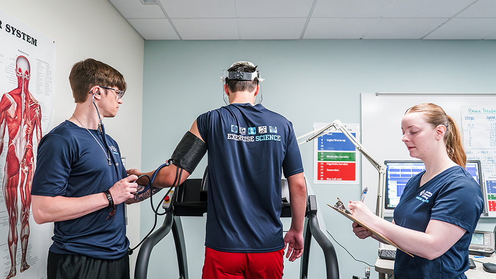 Student working out with an instructor in the gym