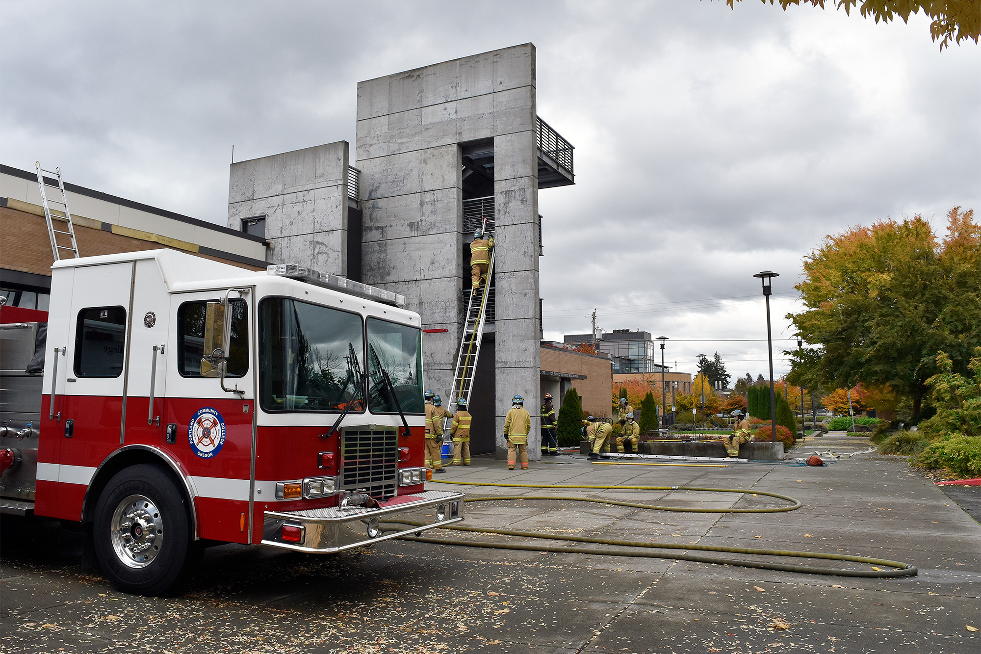 Fire Protection facility and fire truck, with students climbing a ladder in the background