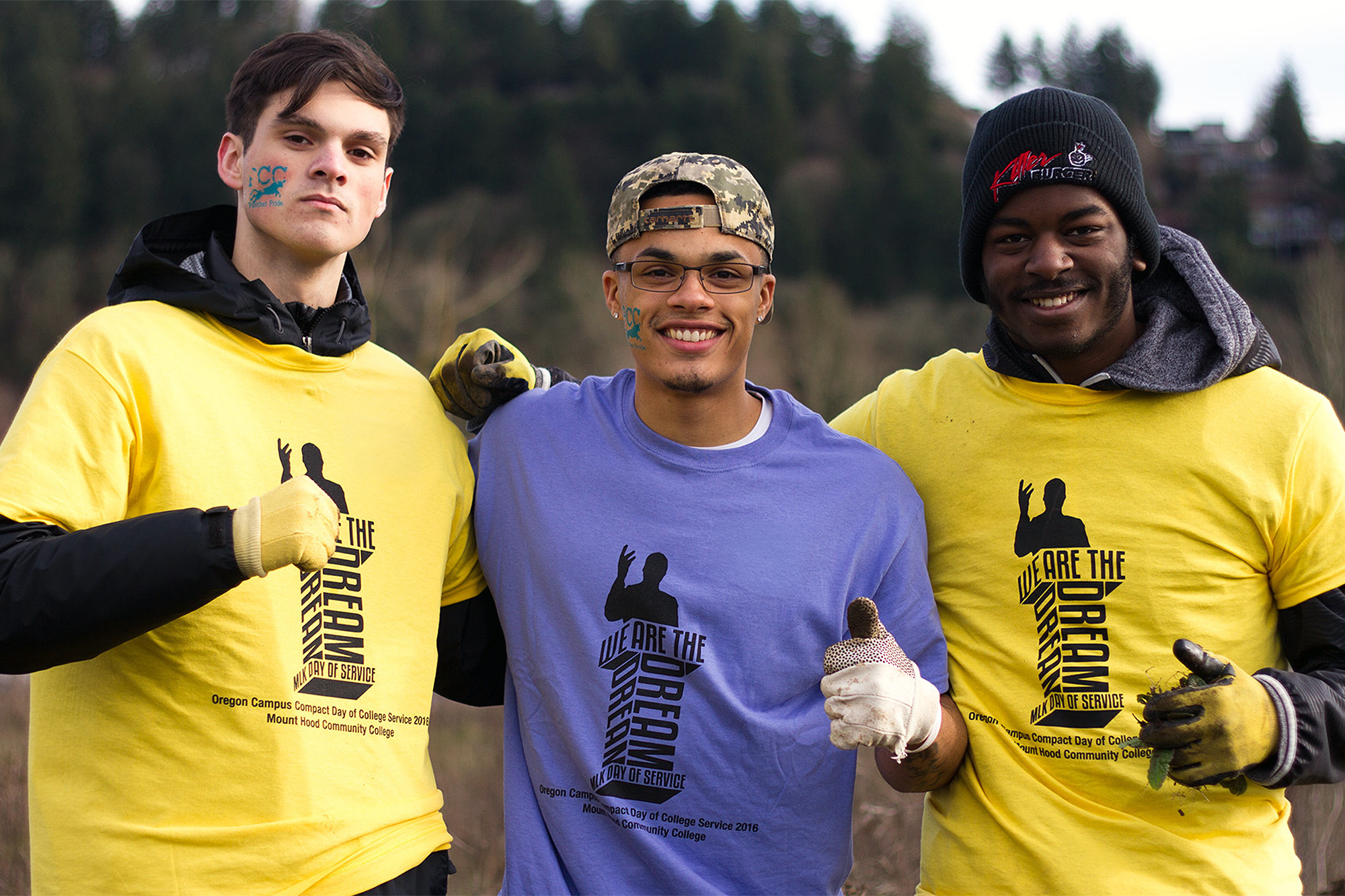 Three students doing work in the community wearing MLK Day shirts